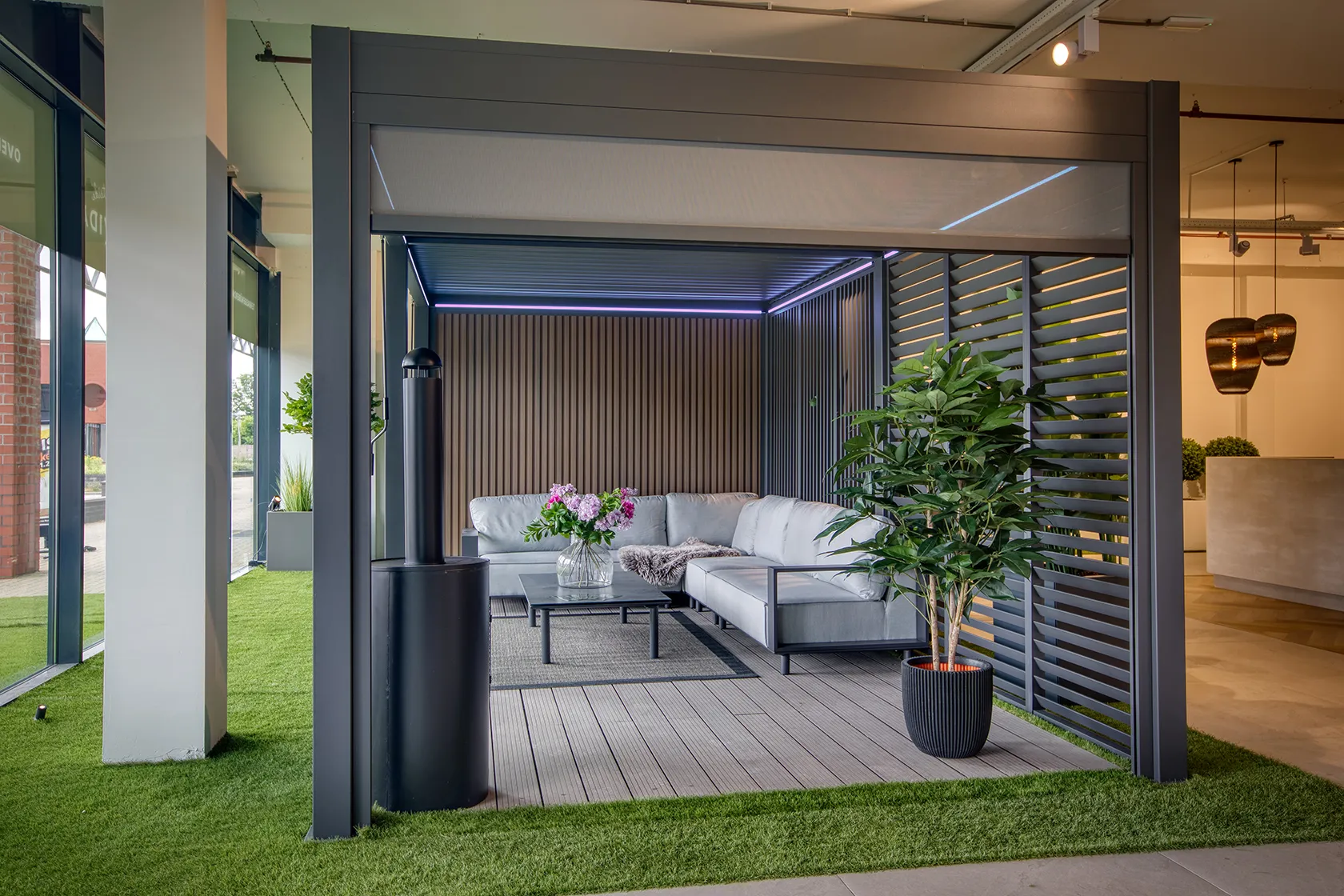 Lamellenoverkapping met screens, verlichting en een zithoek