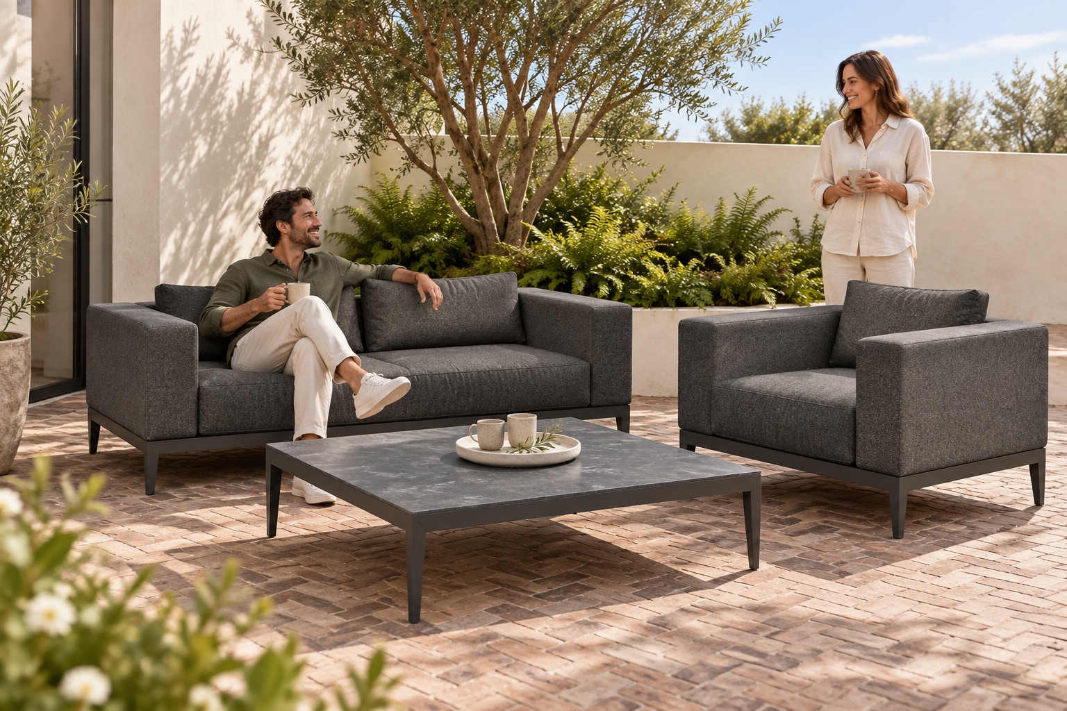 Embrace 2-zitsbank, loungestoel en salontafel op een binnenplaats