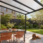 Terrasoverkapping Plus 6 x 4 meter matzwart opaal polycarbonaat moderne goot – onderaanzicht met hond
